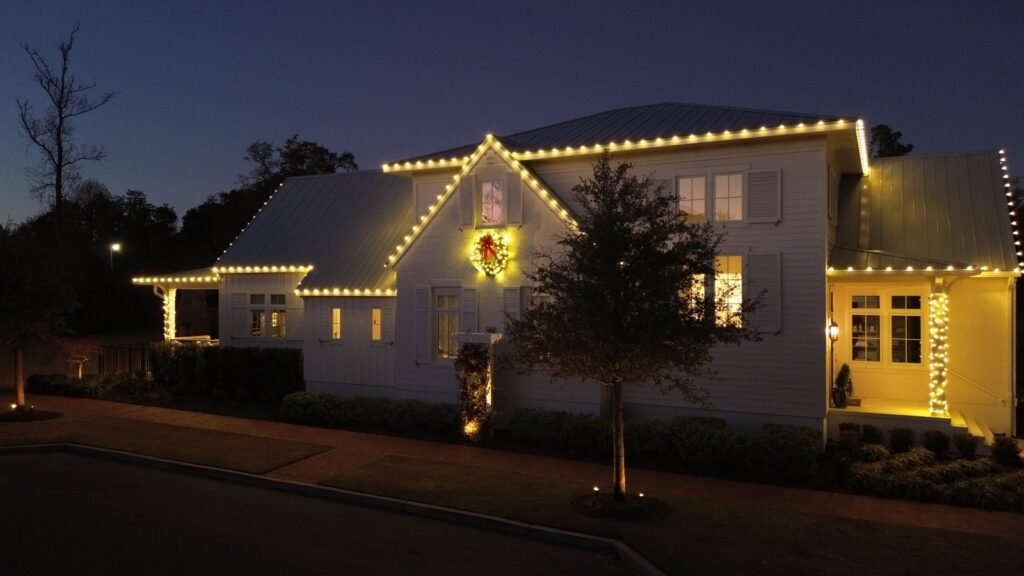 Roofline Christmas lights and a lit wreath on a home by Shark Illumination