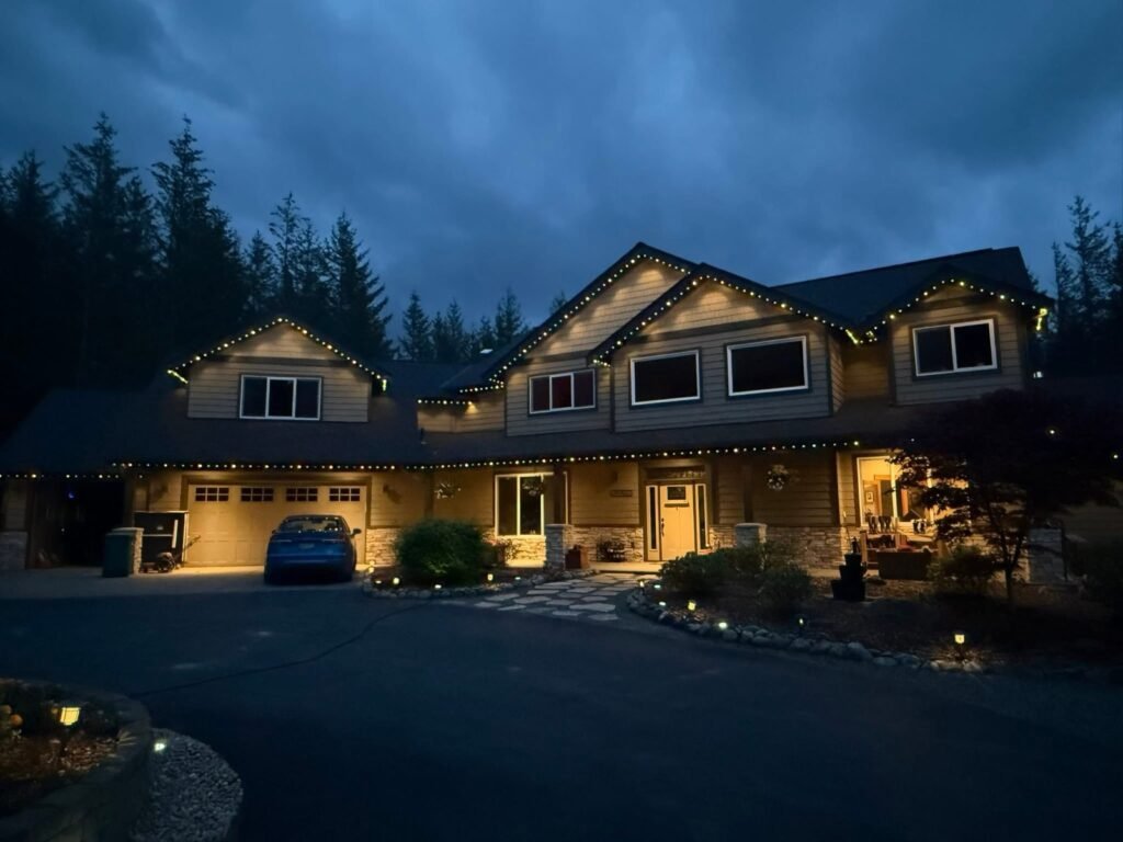 Permanent roofline lighting on a two-story home at dusk by Shark Illumination